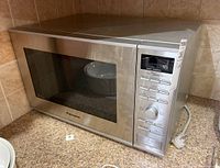 Panasonic microwave oven model NN-SD6715 photographed from side angle showing stainless steel finish and control panel