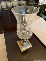 Front side view of Waterford Lismore hurricane shade showing crystal cuts and metal base.