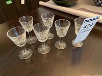 Six Waterford Lismore crystal liqueur glasses arranged in two rows on a wooden surface, clear view of size and pattern.
