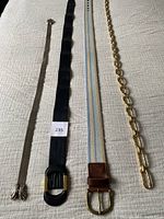 All four belts laid flat showing full length and buckles
