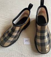 Pair of Burberry ankle boots displayed from top showing iconic checkered pattern and black trim with pull tabs.