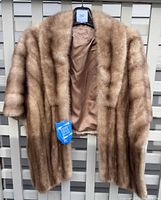 Full view of vintage mink wrap hanging showing light brown fur and open front panels.