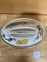 Top view of Evesham lidded casserole with asparagus, lemon, plums painted on lid and gold rim.