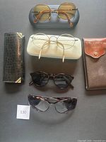 Complete lot view with five pairs of eyeglasses and sunglasses along with three cases