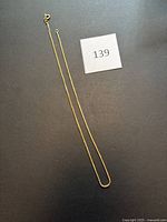 Full view of the necklace laid out with lot marker