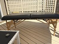 Side view of full massage table showing tabletop, legs and support cables