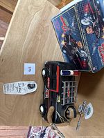 Full lot showing the toy truck, original box, and autographed card on wooden table.