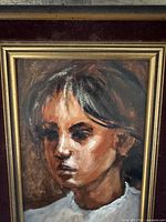 Close-up photo of oil painting showing portrait of a young girl in a velvet and gold-trimmed wood frame