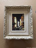 Full front view of framed oil painting showing ornate frame and cityscape image