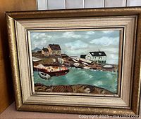 Frontal image of the framed oil painting showing coastal scene with houses and boats.