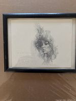 Framed pencil drawing featuring a detailed female profile with floral hair design.