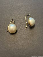 Front view of both earrings showing pearl domes and hooks