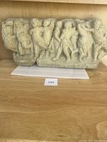 Full frontal view of entire relief panel showing row of six cherubic figures