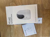 Box front showing Ulofy PT-Cam 2K UHD indoor pan tilt WiFi camera, compatible with Amazon Alexa and Google Assistant, with included manual.