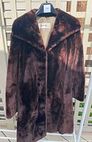 Front view of the vintage chocolate brown beaver fur coat on hanger showing collar and fur texture.