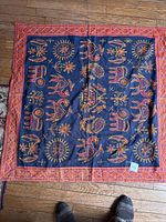 Full view of the embroidered cotton wall hanging laid flat showing entire design and border.