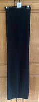 Full length view of one pair of black pants hanging on hanger, smooth fabric with slight flare at bottom