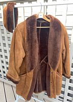 Full view of coat on hanger with matching hat draped