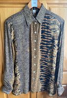 Full front view of Tru animal print sheer blouse with mixed pattern and long sleeves hanging on wooden hanger
