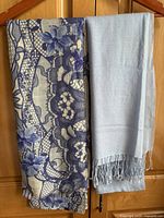 Both wool shawls hanging side by side showing patterns and colors