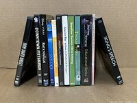 Photo of 12 DVD cases showing titles and artwork in a row.