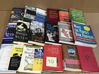 Top view of 19 books laid flat showing spines and covers of various titles.