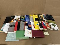 Full view of 27 nonfiction books in a row, showing variety of titles and topics.