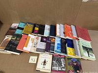 Wide view of all 28 books laid out in cardboard box, showing spines and some covers, various nonfiction topics.