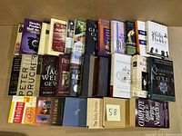 Photo showing 28 nonfiction books laid out side by side, titles visible including 'Quantum Lotus', 'Jack Welch', 'Bill Gates The Road Ahead', and 'Shaping the Next One'. Various colors and cover styles.