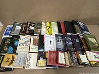 Top-down view of 34 books spread on a surface, showing titles and arrangement covering evolution, biology, and science topics.