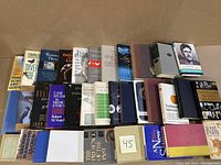 Photo showing 19 books standing upright in two rows with titles spanning philosophy, science, ethics, and evolution.