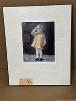 Framed print of a young child saluting, possibly JFK Jr., signed and dated Lynette Wood 1999 with matting and paper label below the print.