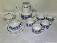 Full tea set showing all cups, saucers, creamer, and teapot together in one image