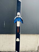 Close-up of Amann Combi ski with blue and white binding, black base, showing brand labeling on the ski.