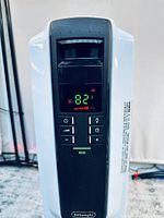 Close up photo of digital control panel showing temperature 82, ECO mode indicator, power and other controls.