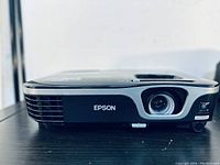 Front view of Epson EX7210 projector showing lens and ventilation grille