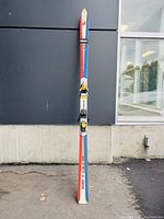 Front view of one K2 Four 98 Derbflex ski showing red, blue, and wood color scheme, with mounted bindings.