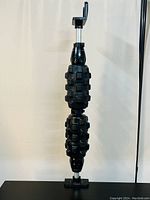 Front view of the black full body roller massager showing the two textured cylindrical rollers mounted vertically with the adjustable mechanism on top.