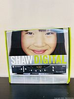 Front view of the boxed Motorola Shaw Digital Cable Receiver with image of smiling girl and branding.