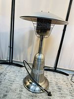 Full view of the Paramount table top propane patio heater showing the dome reflector, safety grill guard, and base with attached hose.