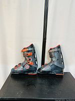 Side view of both left and right Salomon racing ski boots showing the black and red color and buckle adjustments