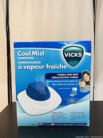 Front view of the Vicks Cool Mist Humidifier box showing product name, image of humidifier, and key features like visible fine mist and air cleaning filter.