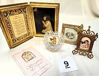 Vintage angel collection showing all five items including the open hinged book style frame with text and praying Samuel image, a white heart-shaped filigree frame with an angel image, the Seraphim Classics pin card with angel pin, and the small brown frame with praying cherub image