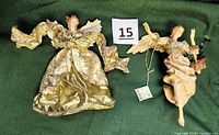 Two 9-inch gold-colored hanging angels displayed on green fabric, showing detailed fabric dress and basket of greens