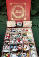 Red hinged box with gold wreath and text 'Bronson Collectibles' on top. Box shown closed and open with dividers containing 25 porcelain kitten figurines.