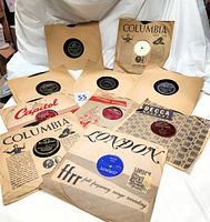 Box of vintage 78 RPM records displayed with visible record labels and original paper sleeves from various 1950s recording studios.