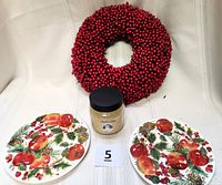 Photo showing all lot items: cranberry wreath, Williamsburg candle, and two Jan Karon Hallmark plates