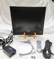 Vuze MS-1501 15-inch LCD TV with remote control, power adapter, AV cable, and user manual laid out.