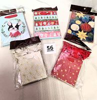 Three packages of larger gift bags (6 x 8 inches) in original packaging showing multiple Christmas and holiday designs including a dog with Santa hat, Christmas ornaments, stars, and festive patterns.