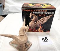Photo showing Firebird figurine in front of the Festival box with clear image of packaging text and unique design details on figurine wings and neck.